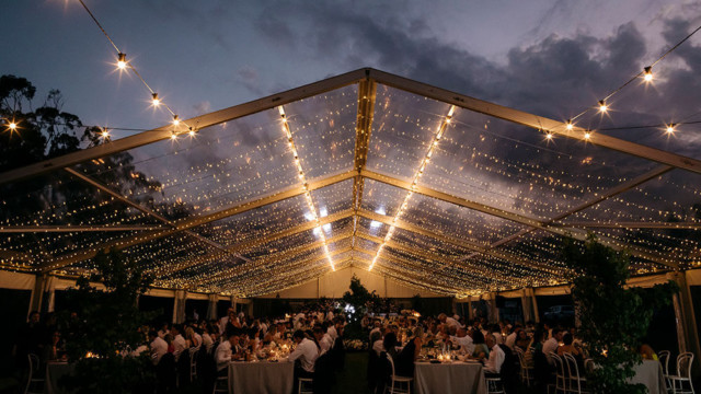 Marquees in Melbourne - A beautifully decorated wedding reception under a tent, adorned with string lights, showcasing a festive atmosphere in Melbourne.