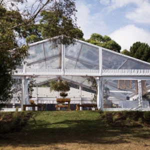 A spacious wedding marquee located in a vibrant field, providing a picturesque setting for a celebration.