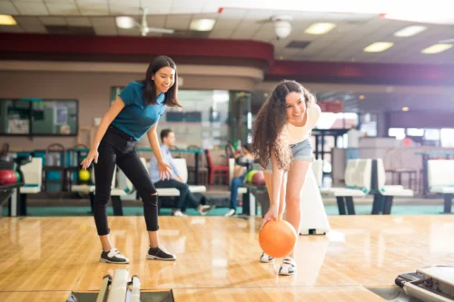 Teen girls enjoying a game of bowling at a birthday party.